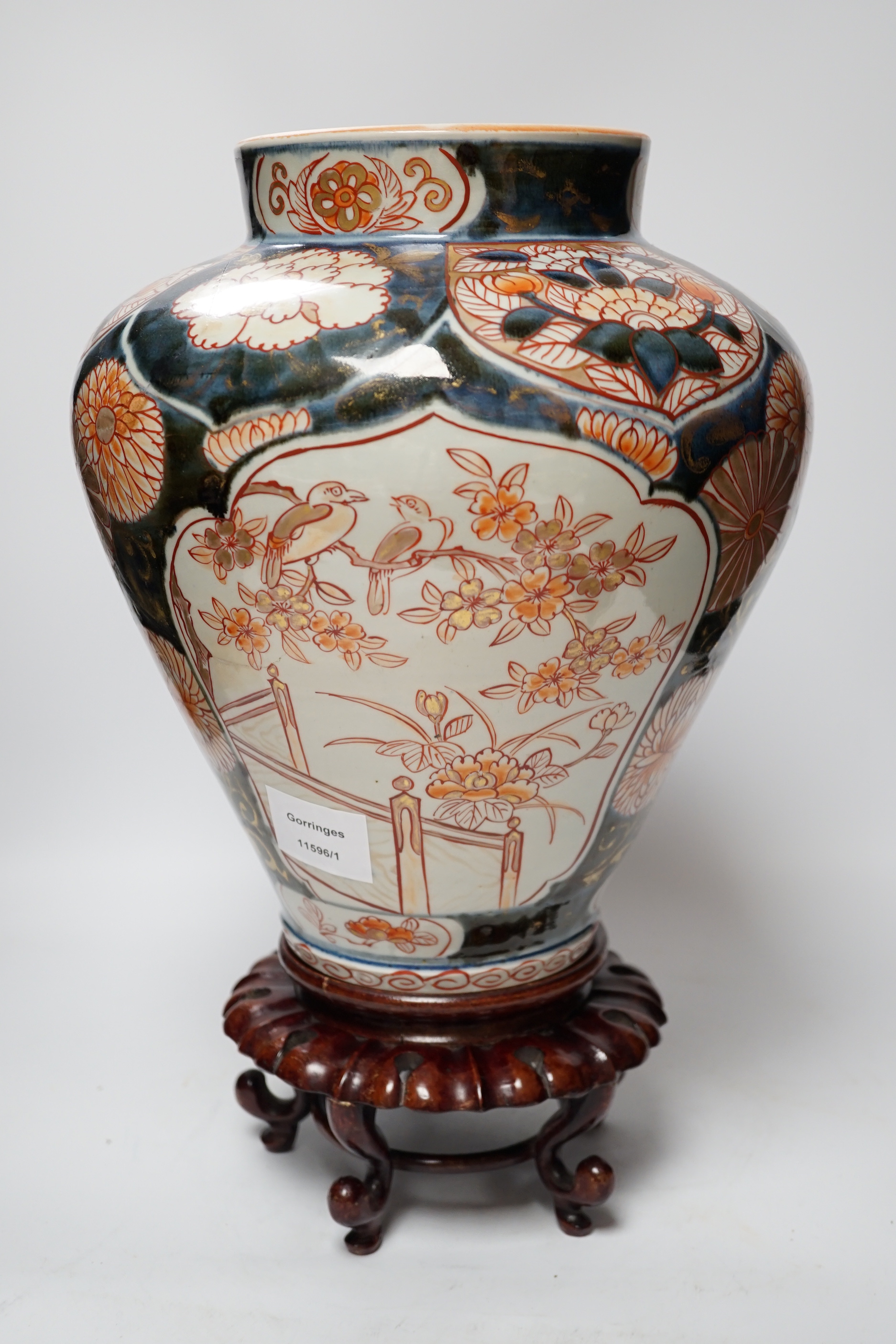 A Japanese Arita Imari pattern vase, c.1690, restored, with an unmatched wooden stand, vase 31cm high